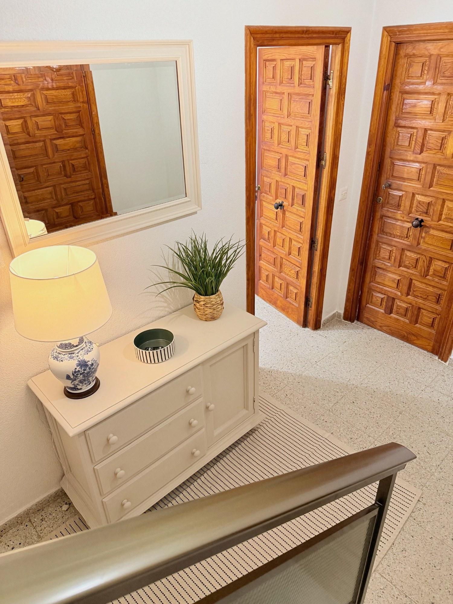 Después: detalle del mueble con lámpara de cerámica, cuenco para las llaves, planta y espejo
